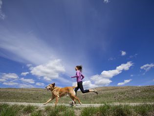 一个女人带着她的狗在跑步